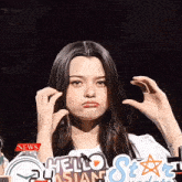 a woman holding up a sign that says hello asian