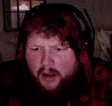 a man with a beard wearing headphones and a hat