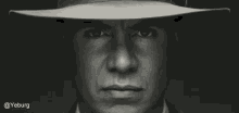 a black and white photo of a man with a hat on his head .
