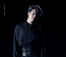 a man in a black shirt with a belt around his waist