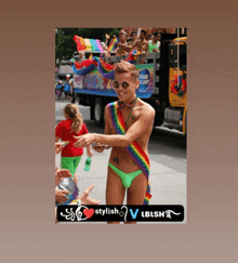 a man in a rainbow colored outfit is standing in front of a bud light truck