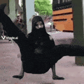 a man in a black hoodie is doing a split with a viggle.ai watermark on the bottom