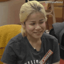 a woman wearing a t-shirt that says klarisse is smiling