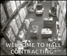 a black and white photo of a warehouse with the words `` welcome to hall contracting '' written on the bottom .