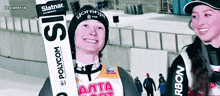 a person holding skis with the word polycom on them