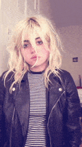 a girl with blonde hair wearing a black leather jacket