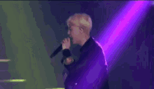 a purple and green light beam is shining on a stage .