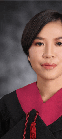 a woman in a graduation gown has a red tassel