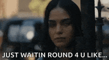 a woman is standing in front of a fence with the words `` just waitin round 4 u like '' .