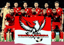 a group of soccer players holding a flag that says timnas garuda on it