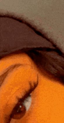 a close up of a person 's eye with a black hat on