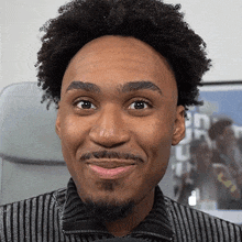 a man with a beard and curly hair is smiling