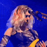 a woman is singing into a microphone while holding a guitar .