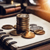 a stack of coins is on top of a notebook .