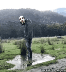 a man is standing in a puddle of water with maleficus origin written on the bottom