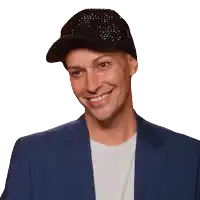 a man wearing a hat and a blue jacket smiles