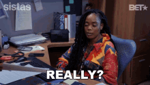 a woman sitting at a desk with the word really written on her face