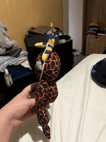a person is holding a stuffed animal with a giraffe print on it