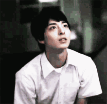 a man in a white shirt looks up at something