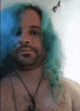 a shirtless man with blue hair and a necklace