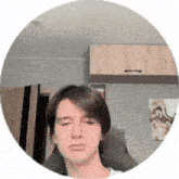 a young man is sitting in a chair with his eyes closed and making a funny face .
