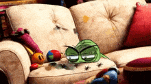 a cartoon frog is sitting on a couch with bugs on it .