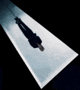 a person is hanging upside down from a rope in a dark room