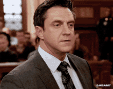 a man in a suit and tie with barbabot on the bottom