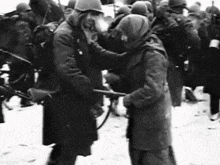 a black and white photo of a group of soldiers standing in the snow