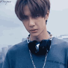a young man wearing headphones around his neck and a t-shirt that says sounds bmuette