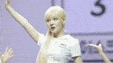 a girl in a white shirt is dancing in front of a sign that says 3 on it