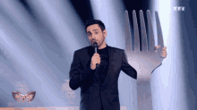 a man in a suit is holding a large fork in his hand