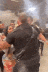 a man and woman are fighting in a crowded room .