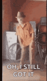 an elderly man in a hat is dancing in a garage and says `` oh , i still got it '' .