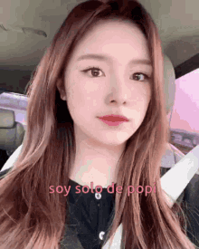 a woman is sitting in a car with the words soy solo de pop on her face