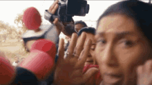 a woman is standing in front of a crowd of people holding microphones and a camera .