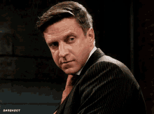 a man in a suit and tie has barbabot written on the bottom right