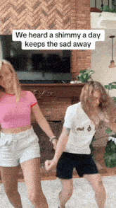 two women are dancing in front of a fireplace with the caption " we heard a shimmy a day keeps the sad away