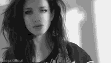 a black and white photo of a woman with long hair and a sad look on her face .