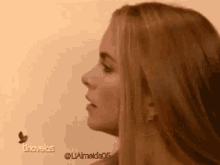 a close up of a woman 's face with a butterfly behind her and the words tnovelas on the bottom right