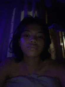 a woman laying on a bed with purple lights behind her