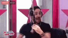a man wearing headphones is talking into a microphone in a radio studio .
