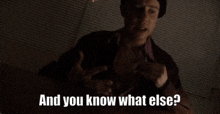 a man in a hat is talking to someone in a dark room .