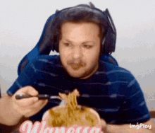 a man wearing headphones is eating noodles with a fork and knife .
