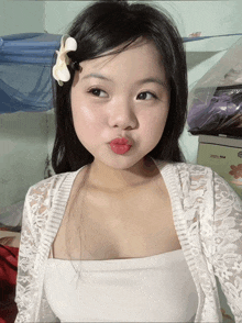 a girl with a flower in her hair is wearing red lipstick