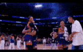 a group of women hugging each other on a basketball court .