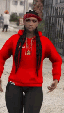 a woman wearing a red hoodie and a bandana is standing on a sidewalk