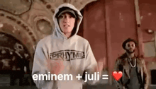 eminem and juli are standing next to each other in a room .
