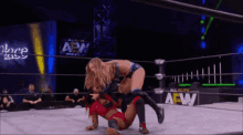two women are wrestling in a ring with a sign that says aew