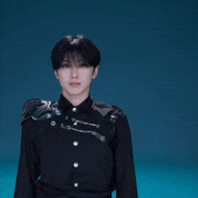 a young man wearing a black jacket with a shoulder armor